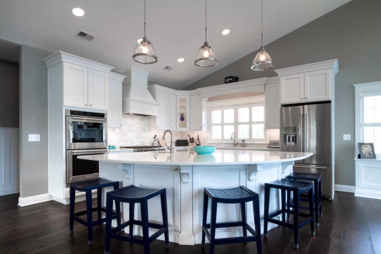 kitchen area with a white island and five black chairs