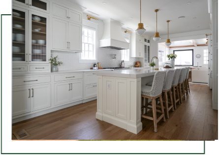 A kitchen with white cabinets and wooden floors