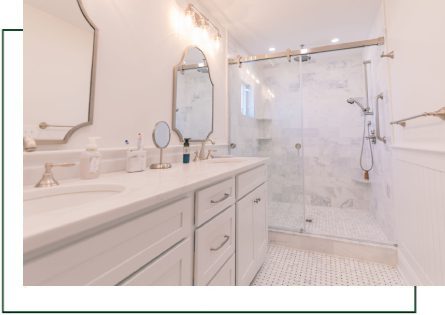 A bathroom with two sinks and a walk in shower.
