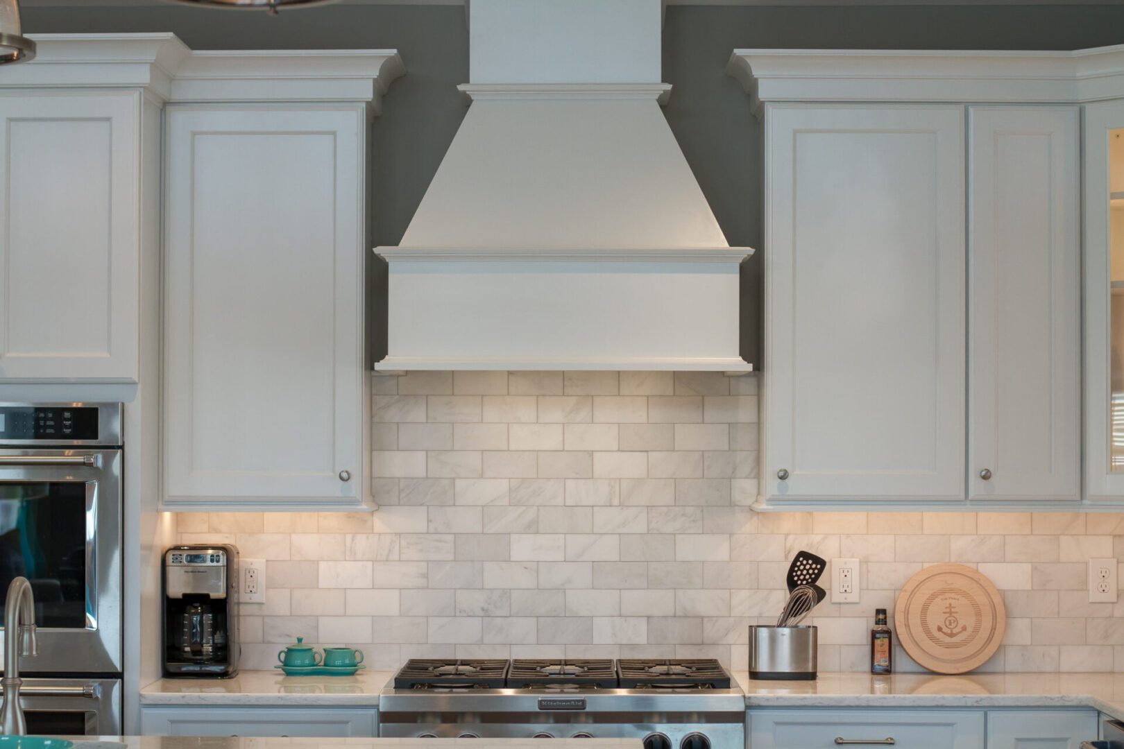 White kitchen range hood and cabinets.
