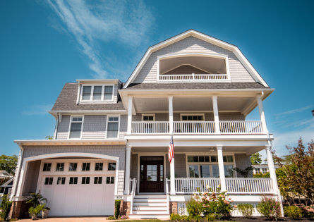 Gray house with a white porch and garage.