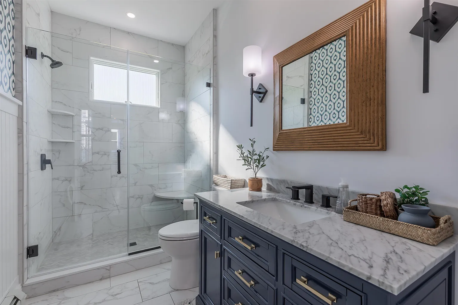 Modern marble bathroom with navy vanity.