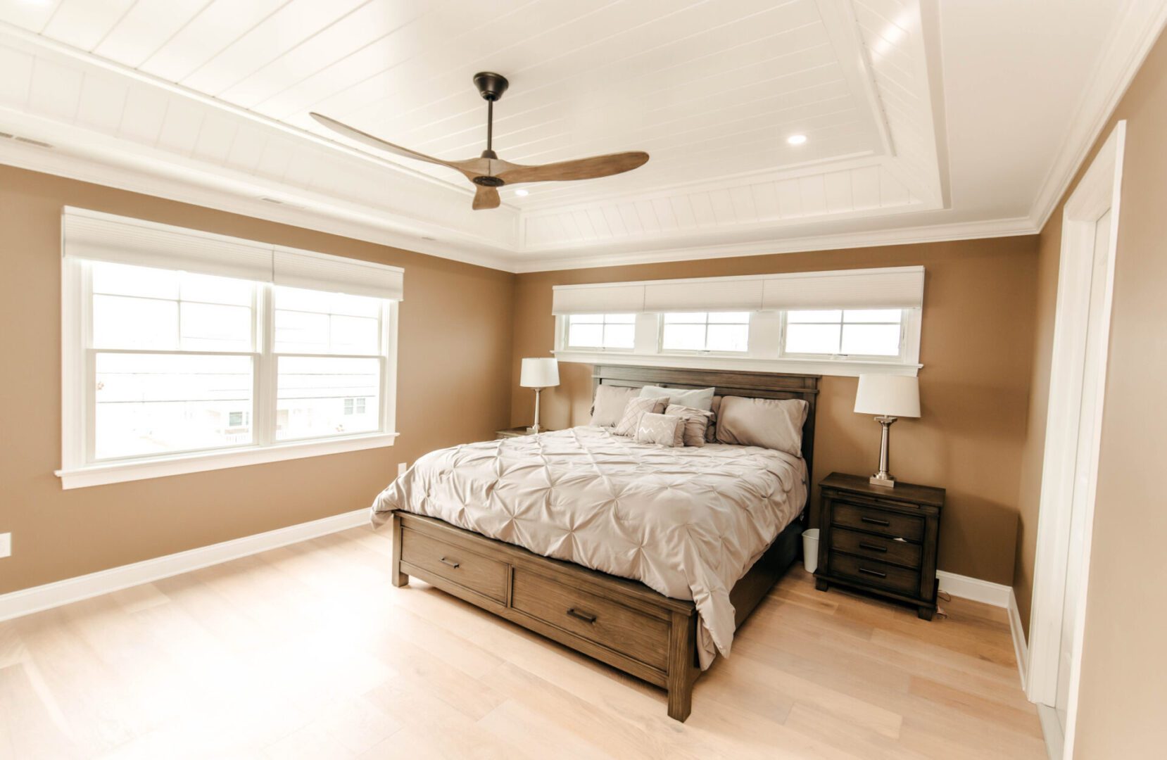 Master bedroom with king-size bed and ceiling fan.