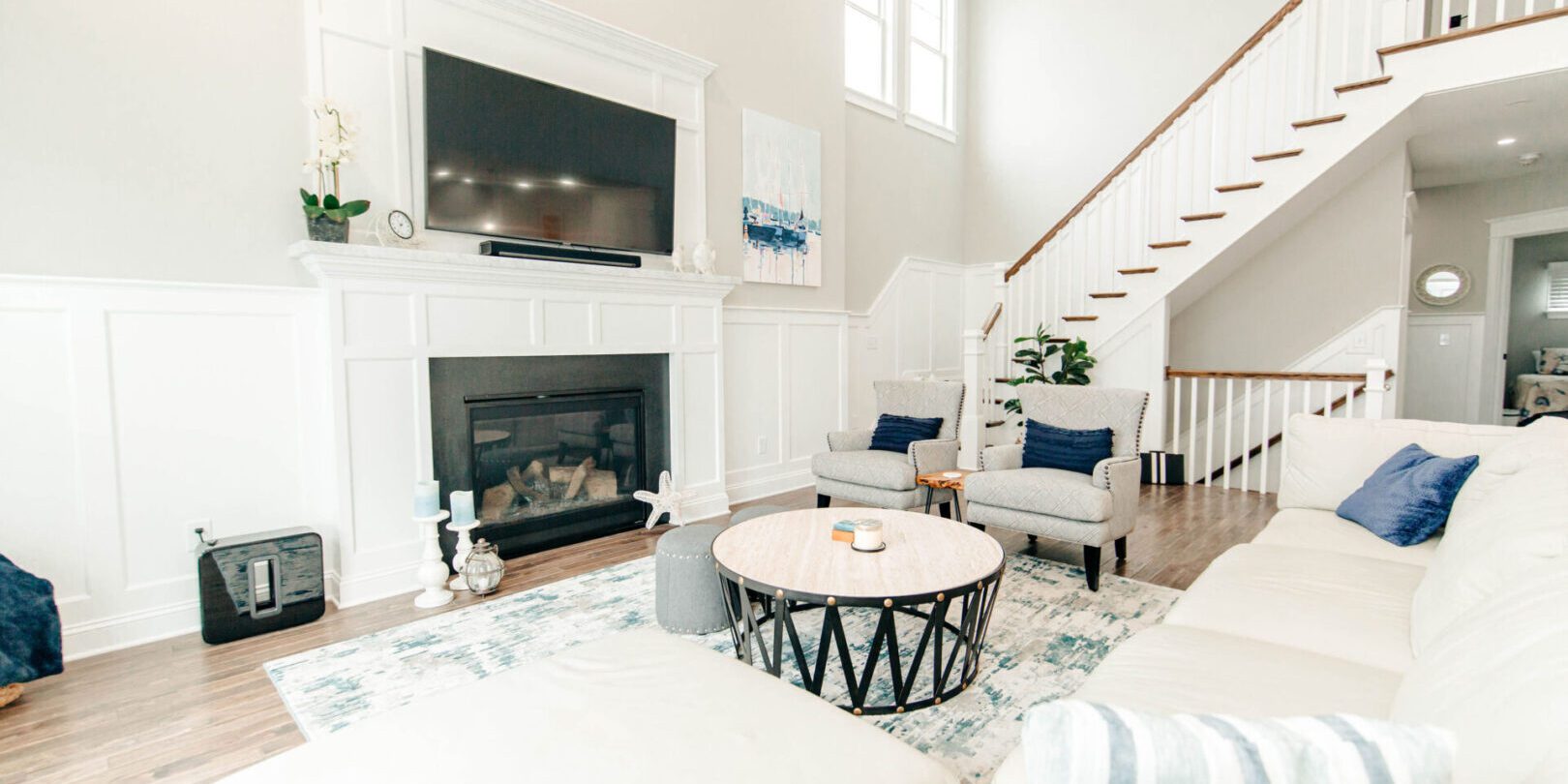 A living room with white furniture and fireplace.